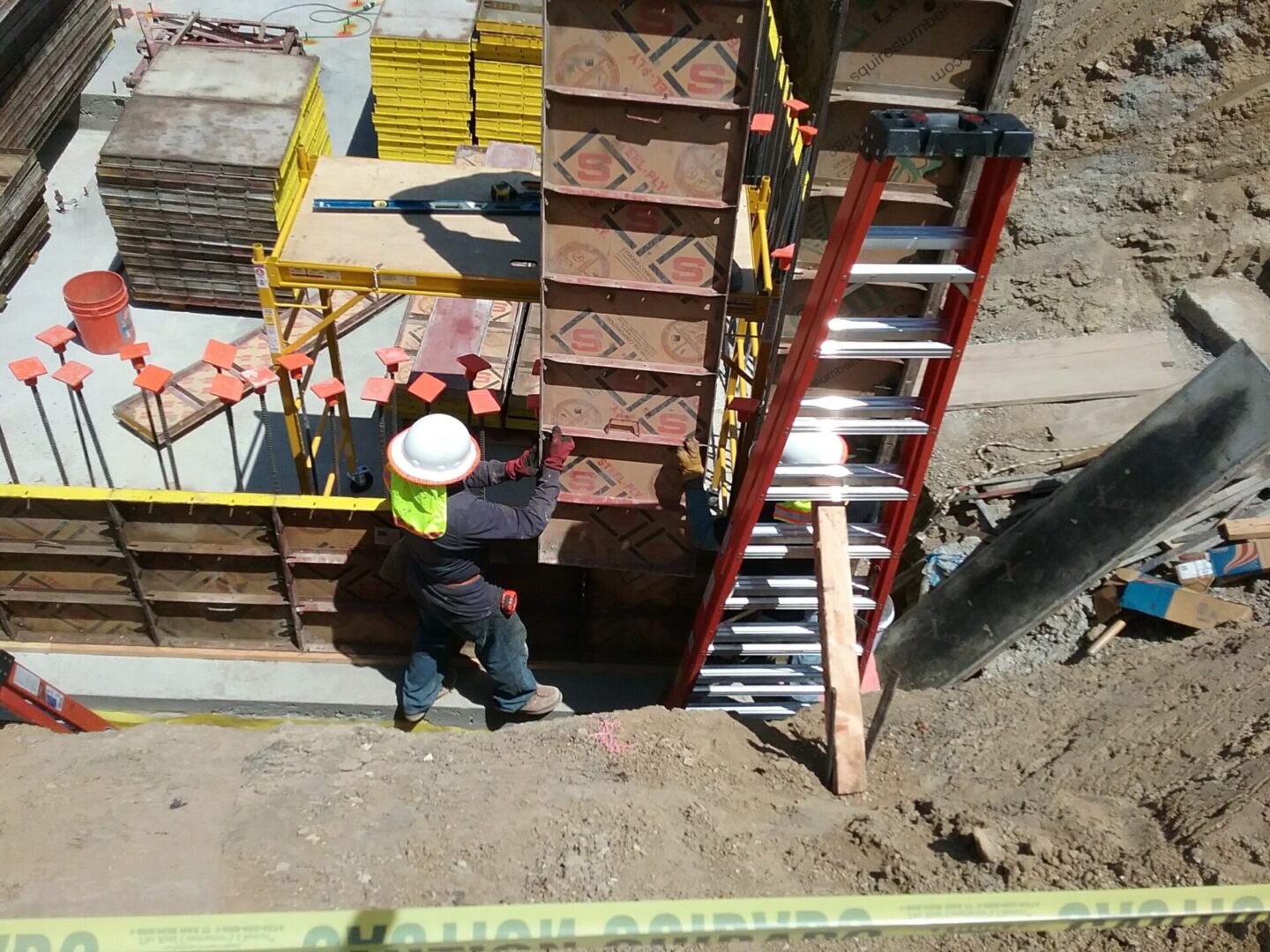 A construction worker is climbing up the stairs.