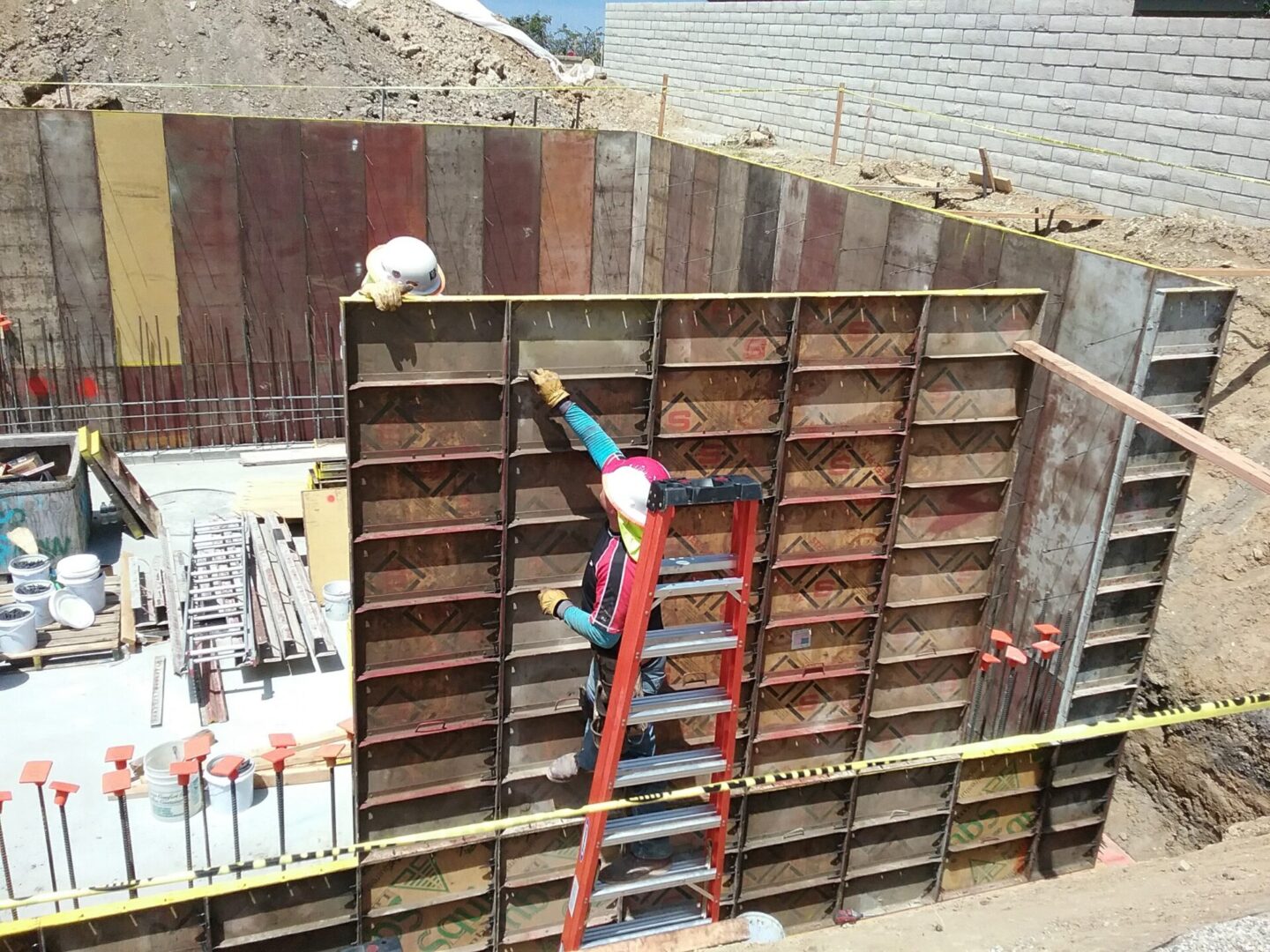 A man on a ladder working on the side of a building.