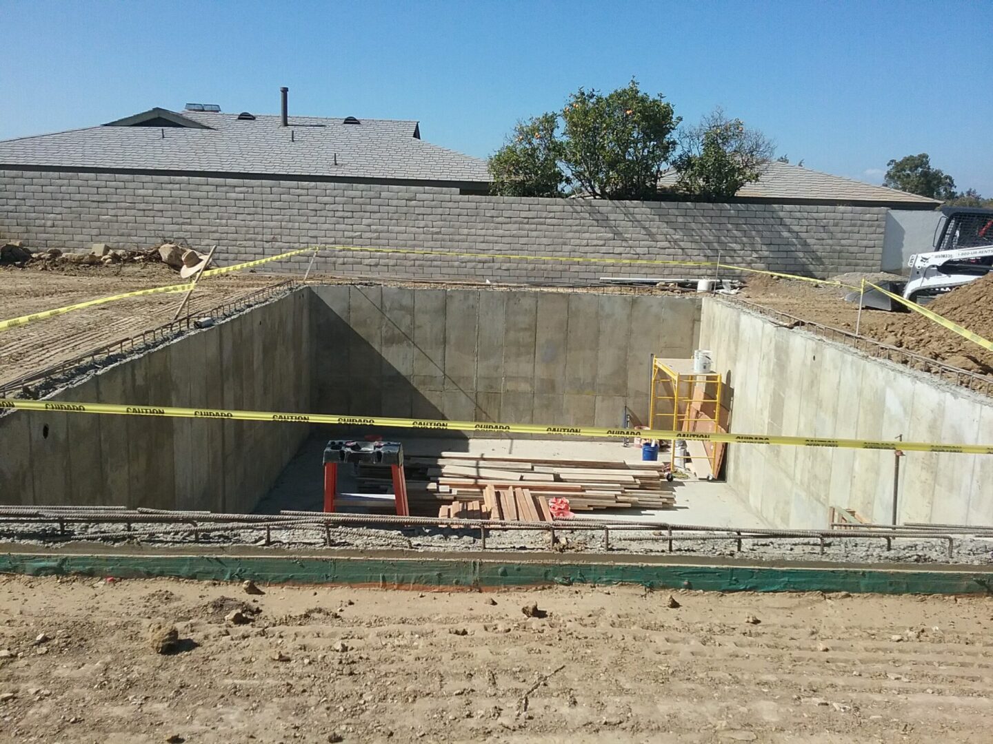 A construction site with cement walls and yellow tape.