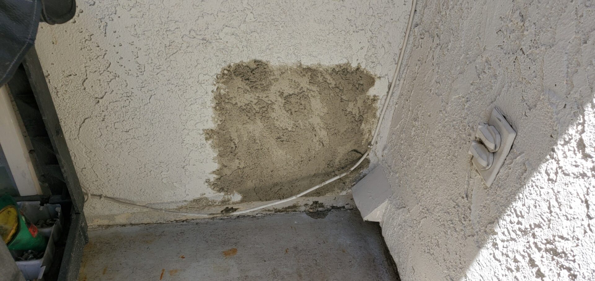 A wall with some dirt on it and wires