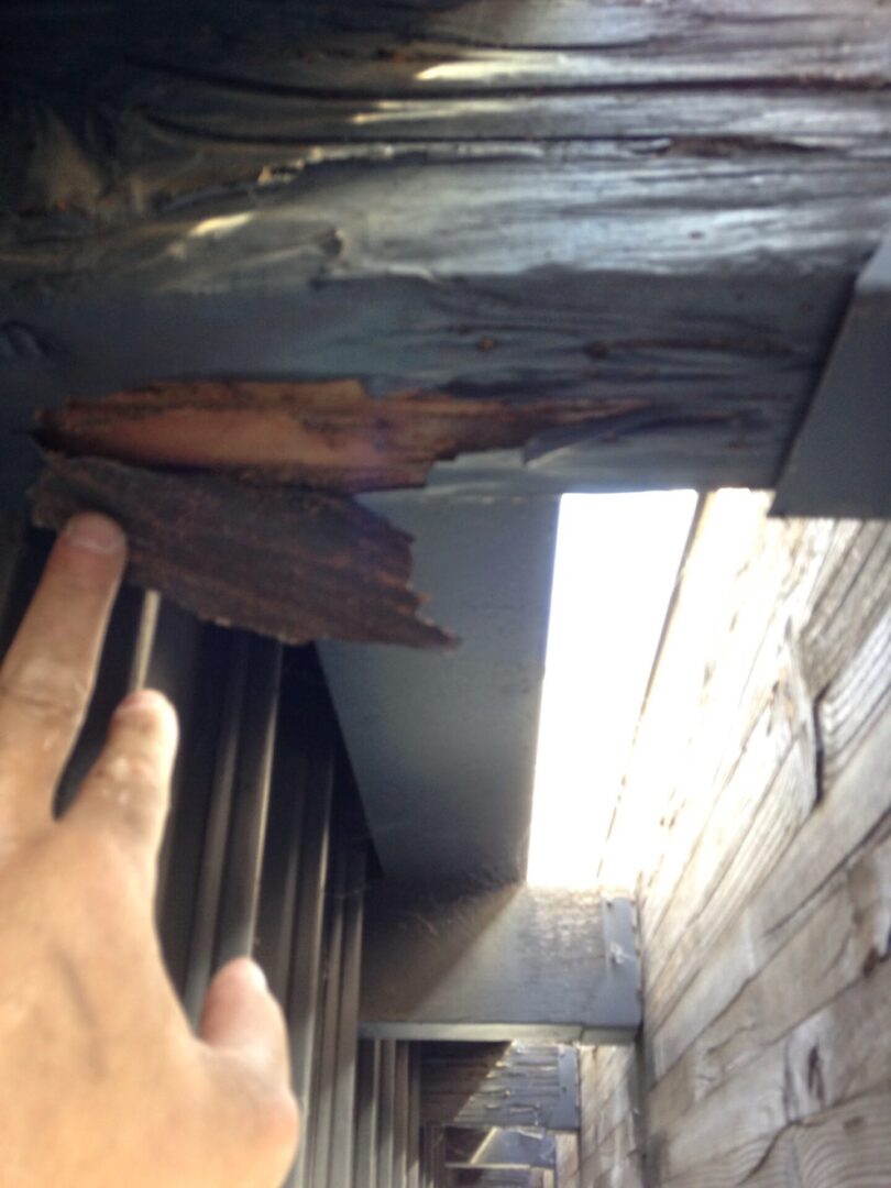 A person touching the wood on the outside of a building.