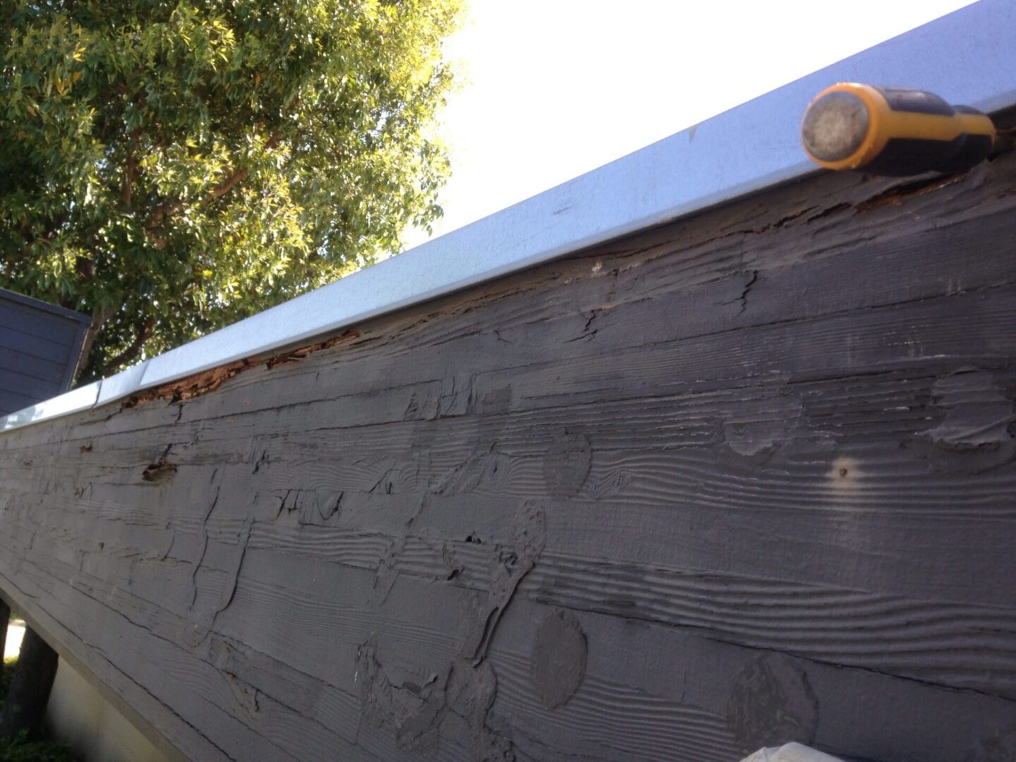 A wooden wall with a metal roof on it.