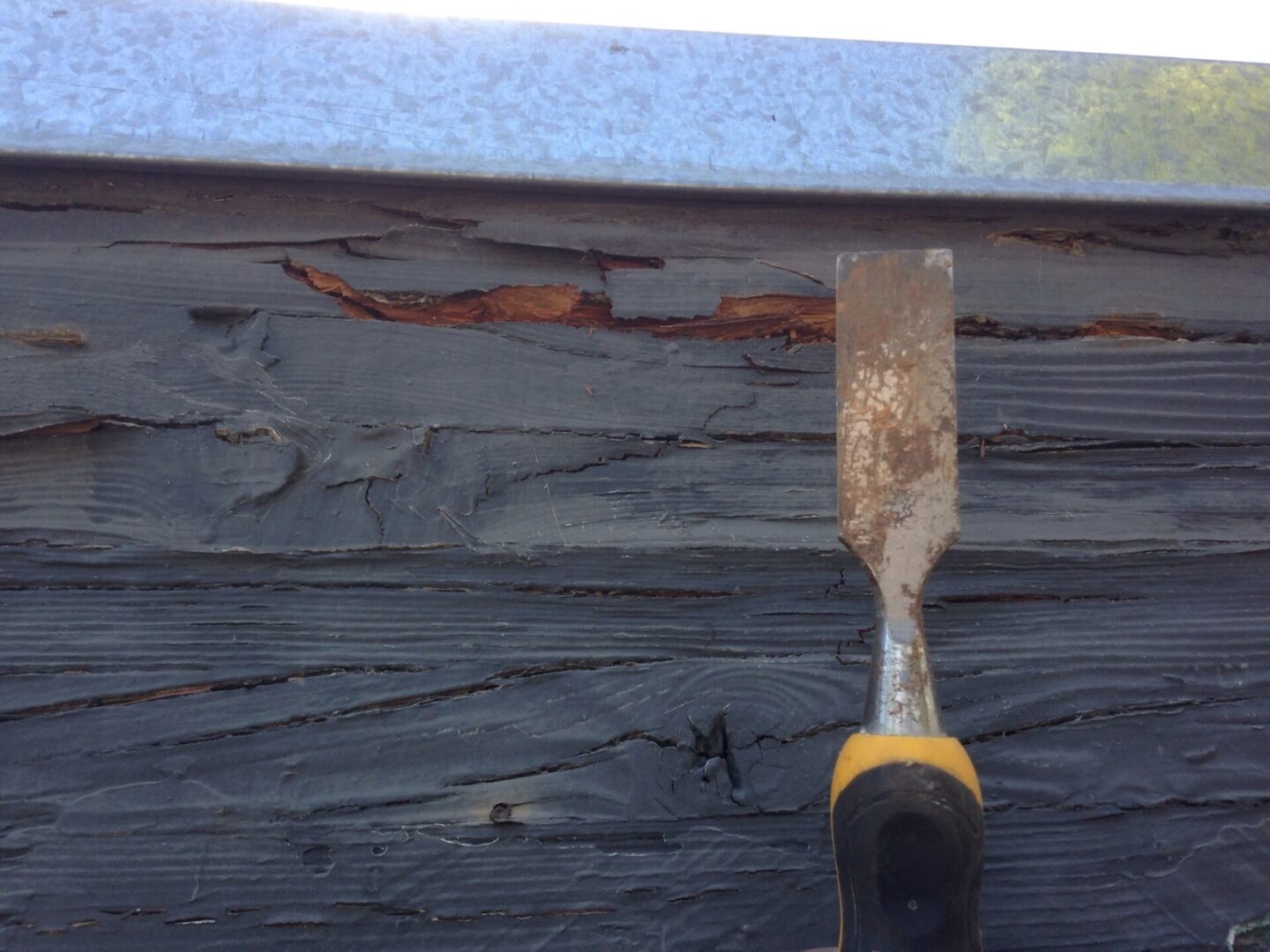 A close up of a wood chisel on the side of a building.