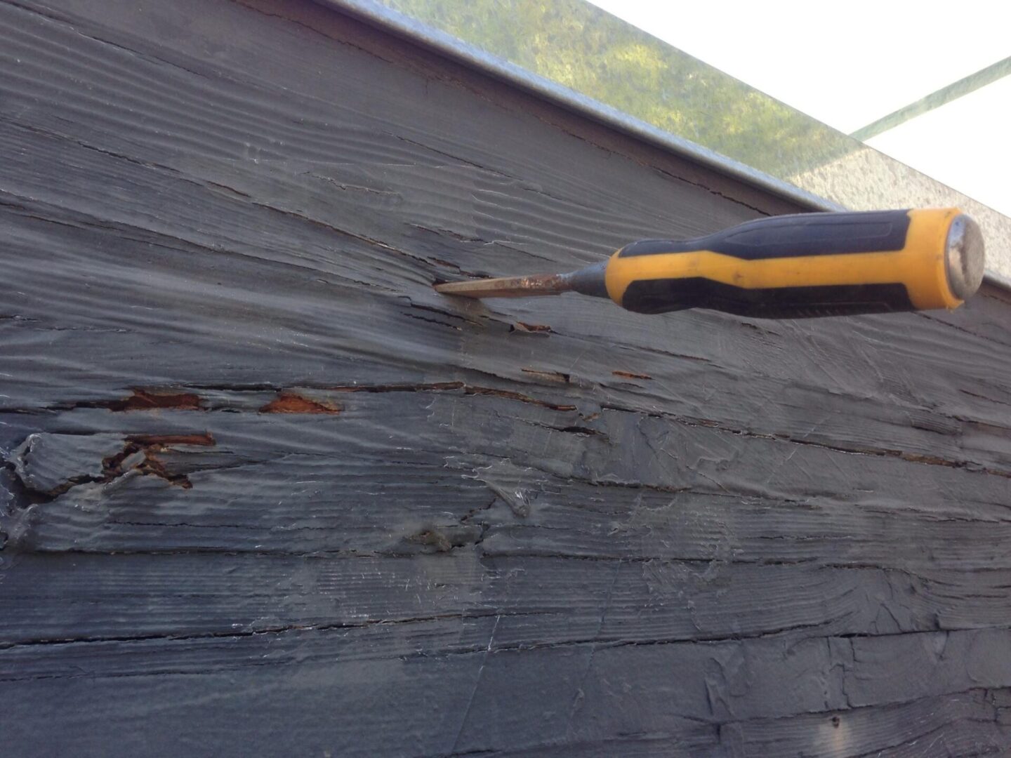 A close up of the side of a house with peeling paint.