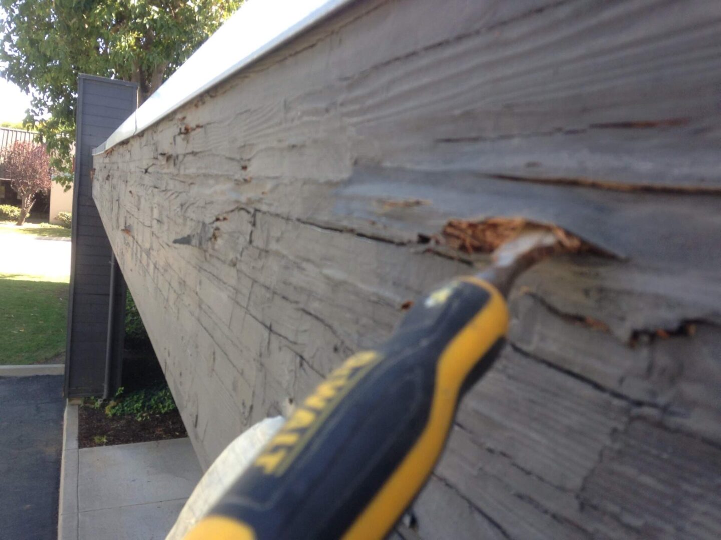 A close up of a person using a tool to fix the wall