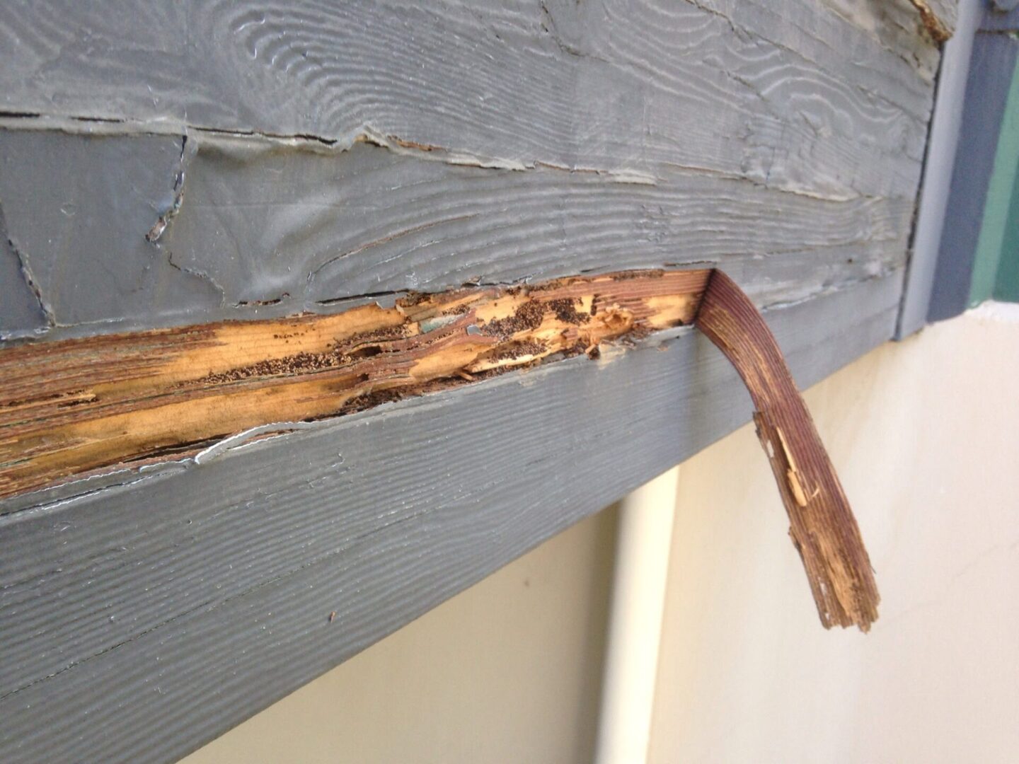 A close up of the side of a house with rust on it.