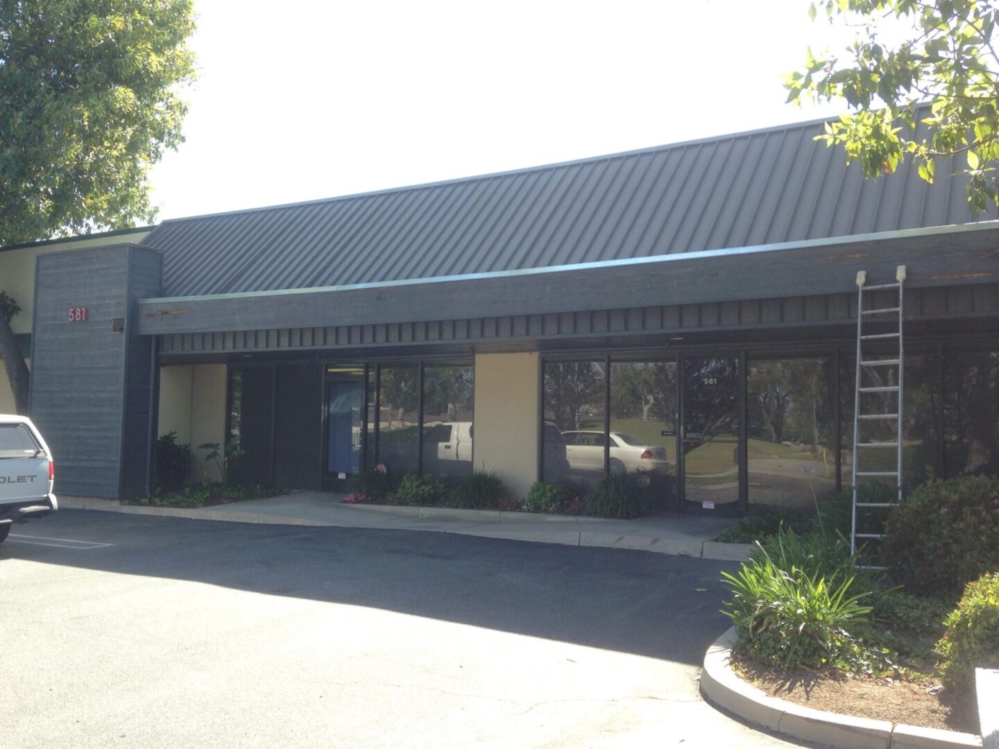 A building with a large window and a metal roof.