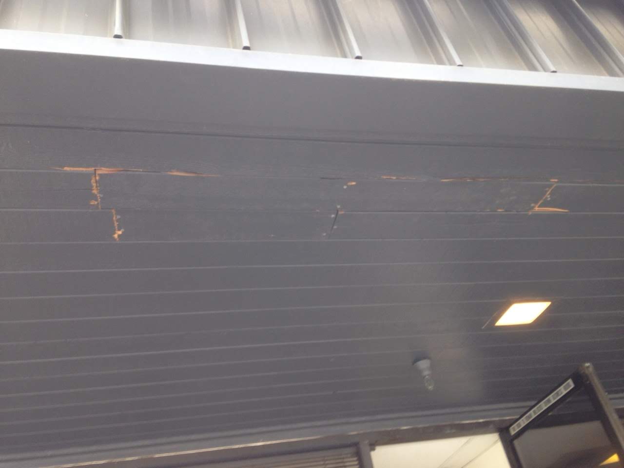 A garage door that has been painted black.