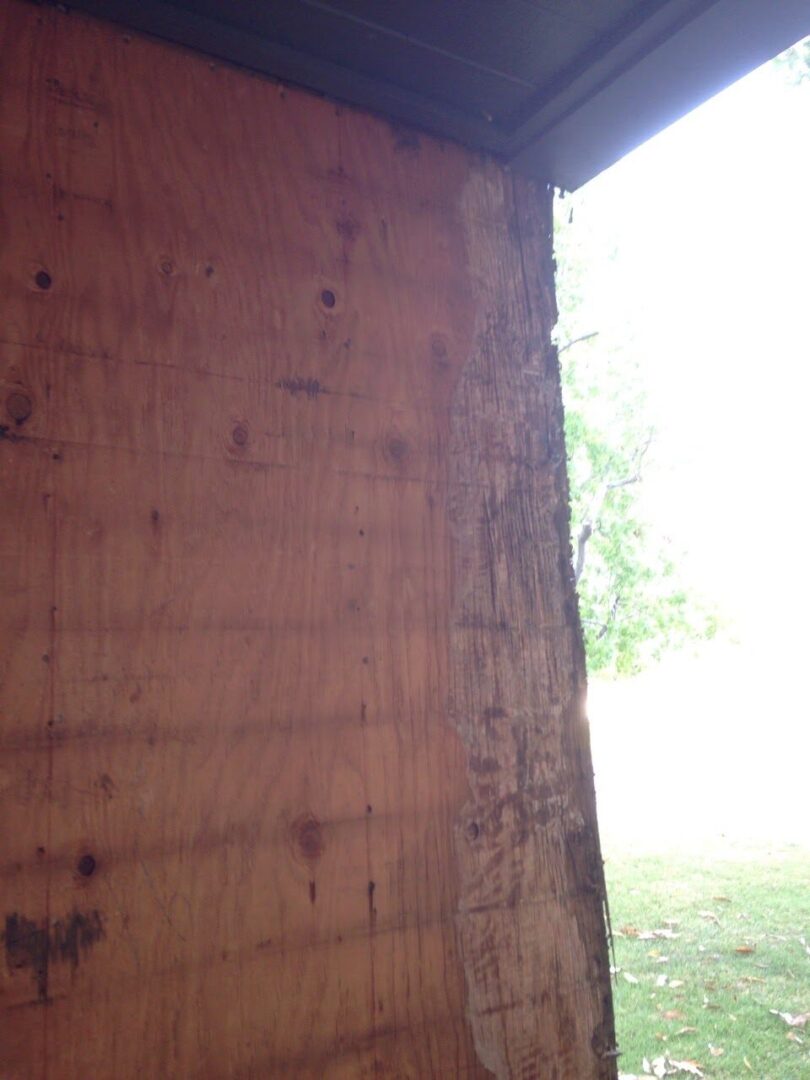 A wooden wall with some trees in the background