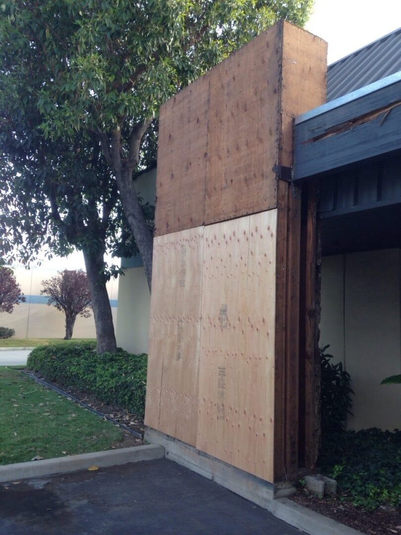 A building with plywood on the side of it.