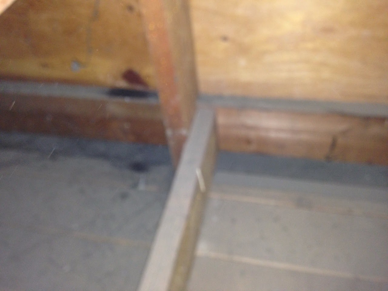 A wooden beam in the middle of an unfinished room.