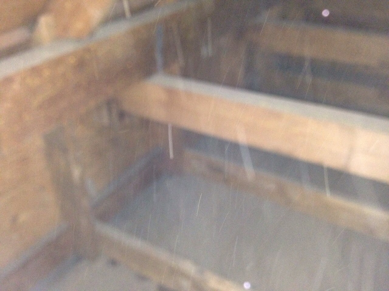 A blurry picture of some wood in the attic.