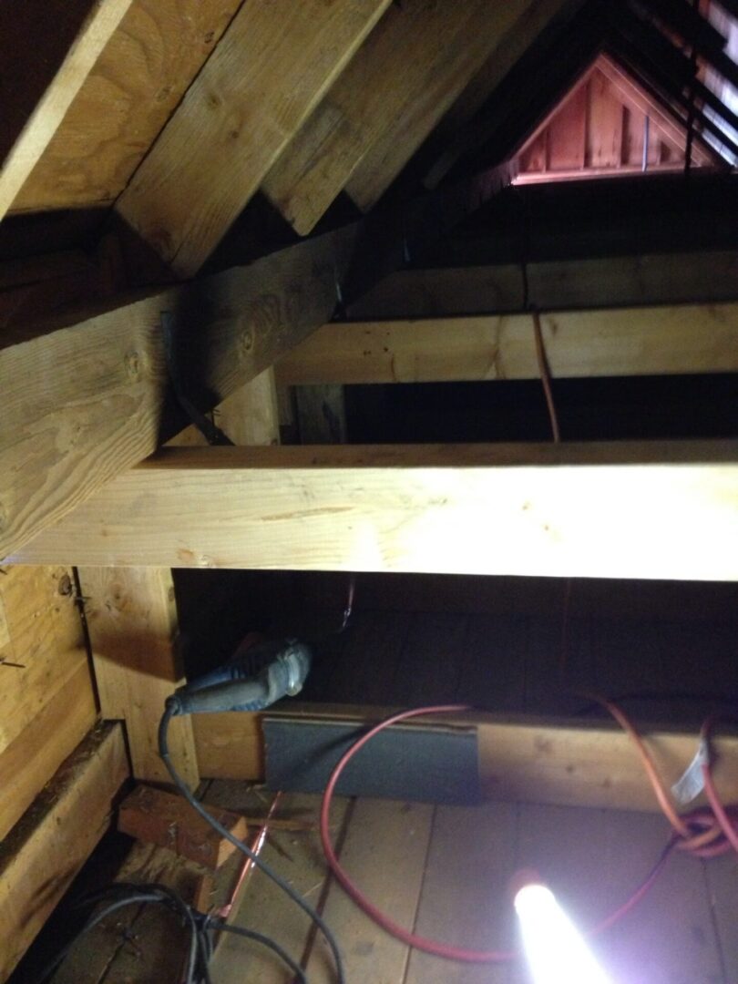 A view of the inside of an attic with wood flooring.