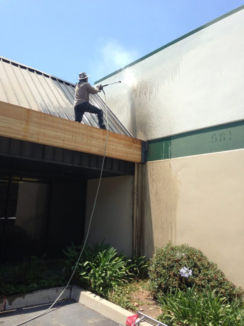 A man is cleaning the roof of an office building.