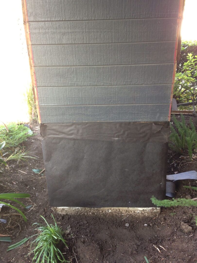 A wooden structure with a black tarp covering it.