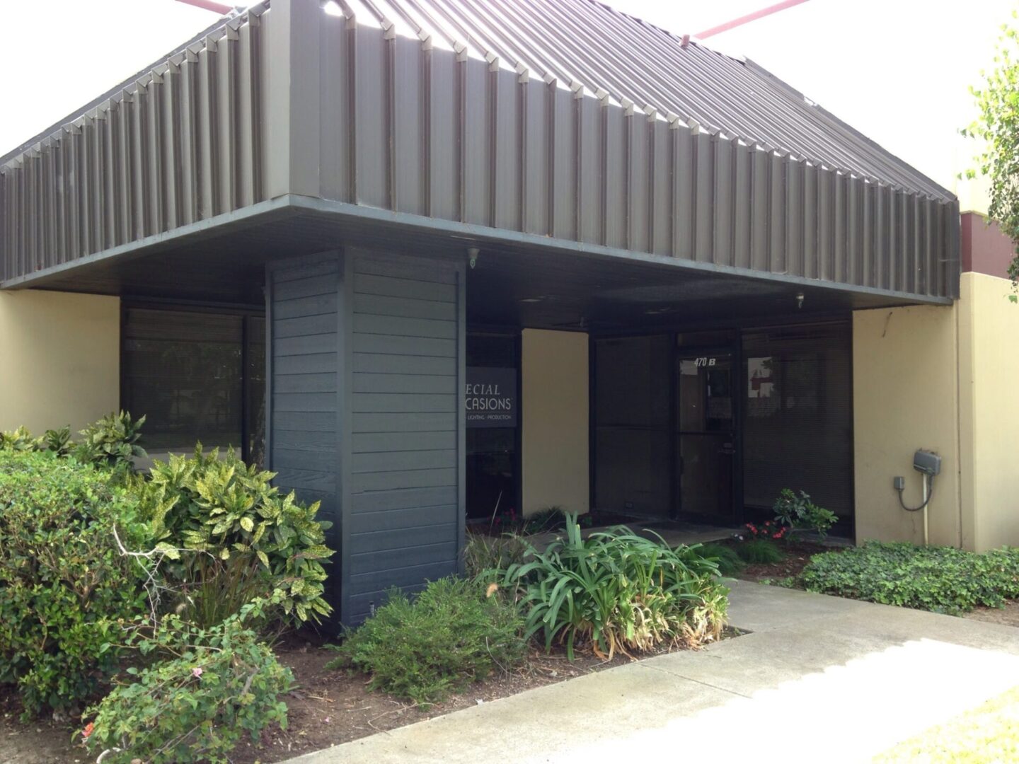 A building with plants and bushes outside it