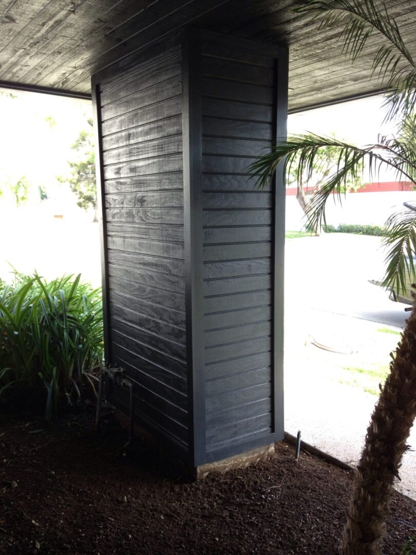 A corner of a building with a palm tree in the background.