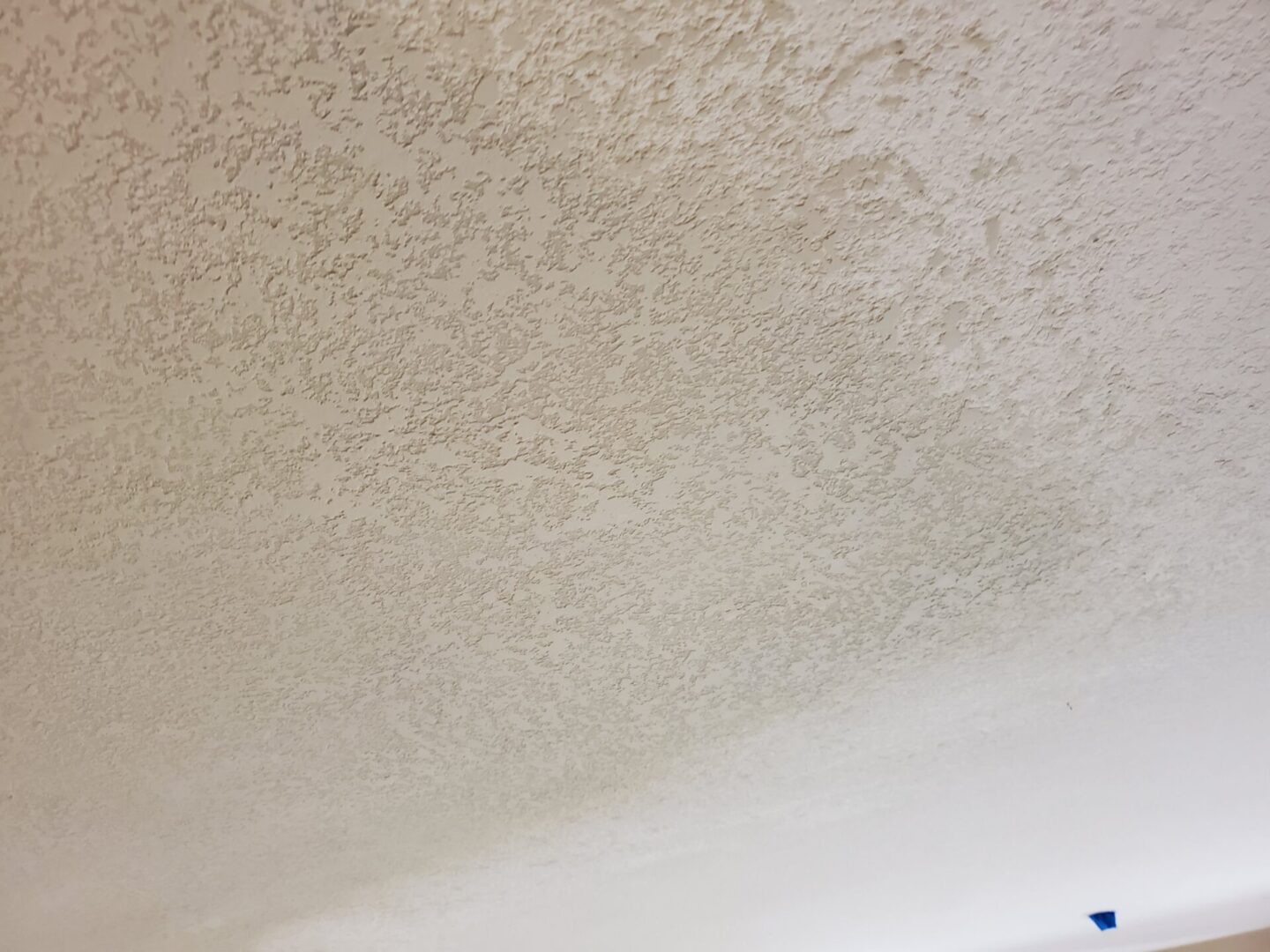 A white ceiling with some small spots of paint