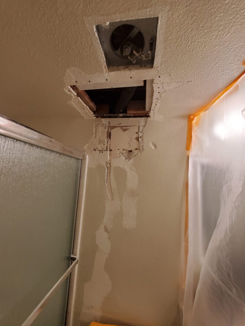 A bathroom ceiling with holes in it and the shower curtain.