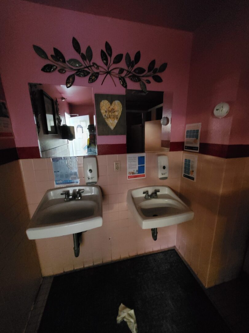 A couple of sinks in a bathroom next to a mirror.