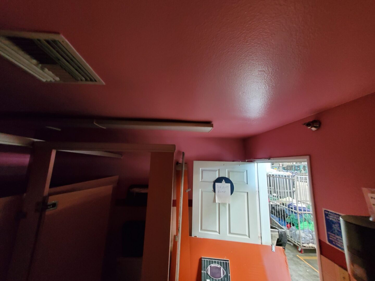 A room with pink walls and orange door.