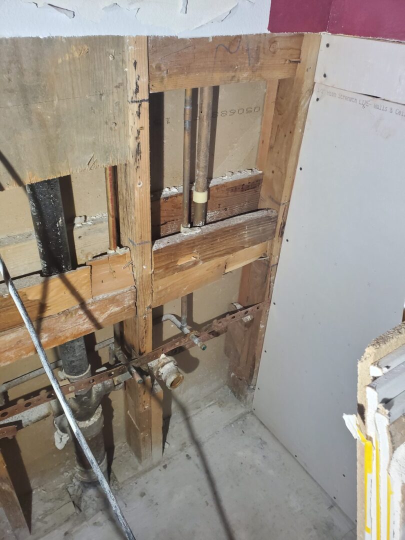 A bathroom with wood walls and floors being remodeled.