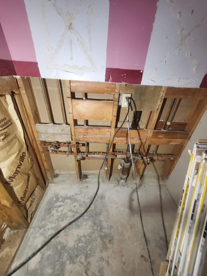 A bathroom with wood walls and floors being remodeled.