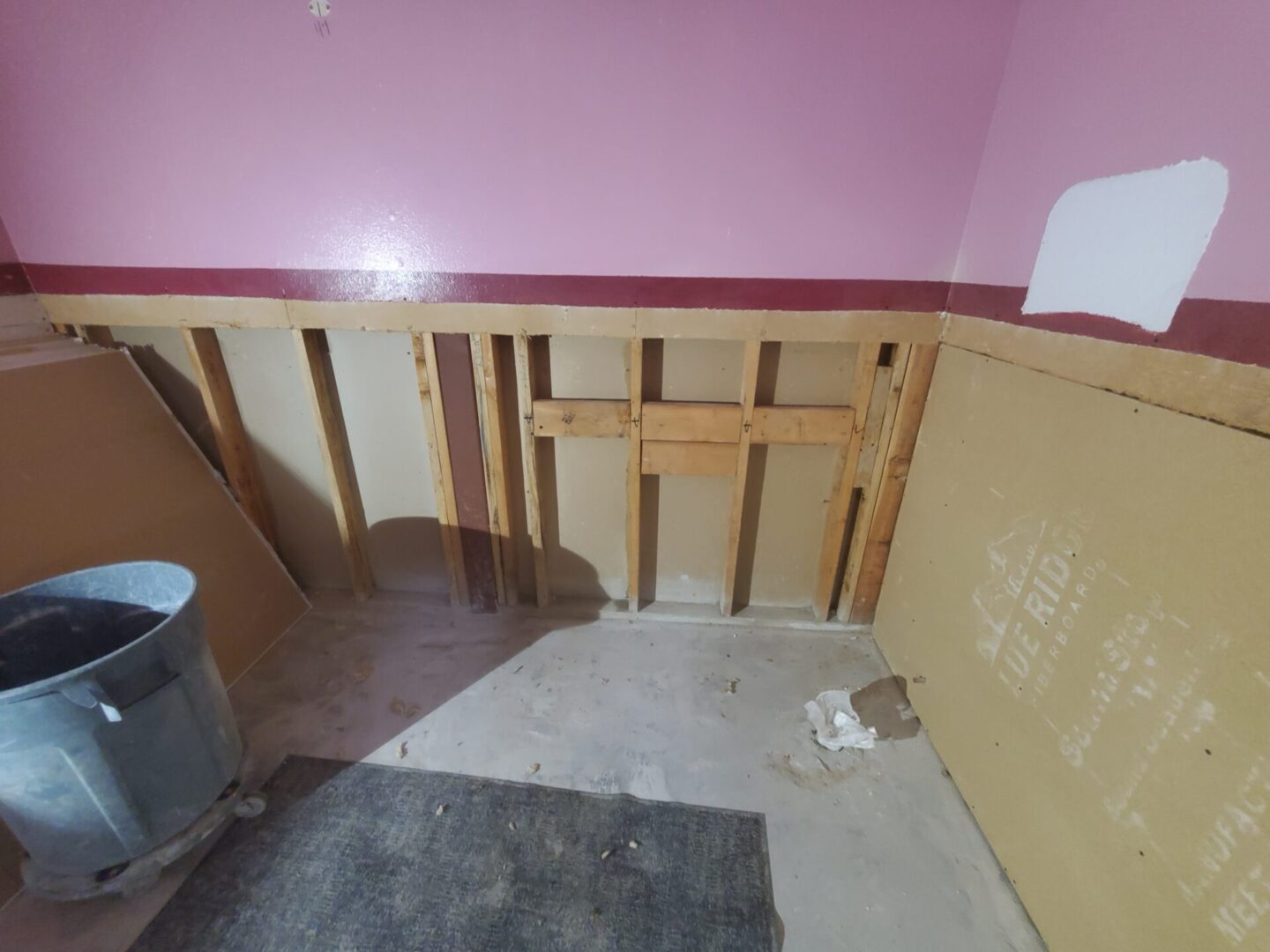 A room with pink walls and wood paneling.