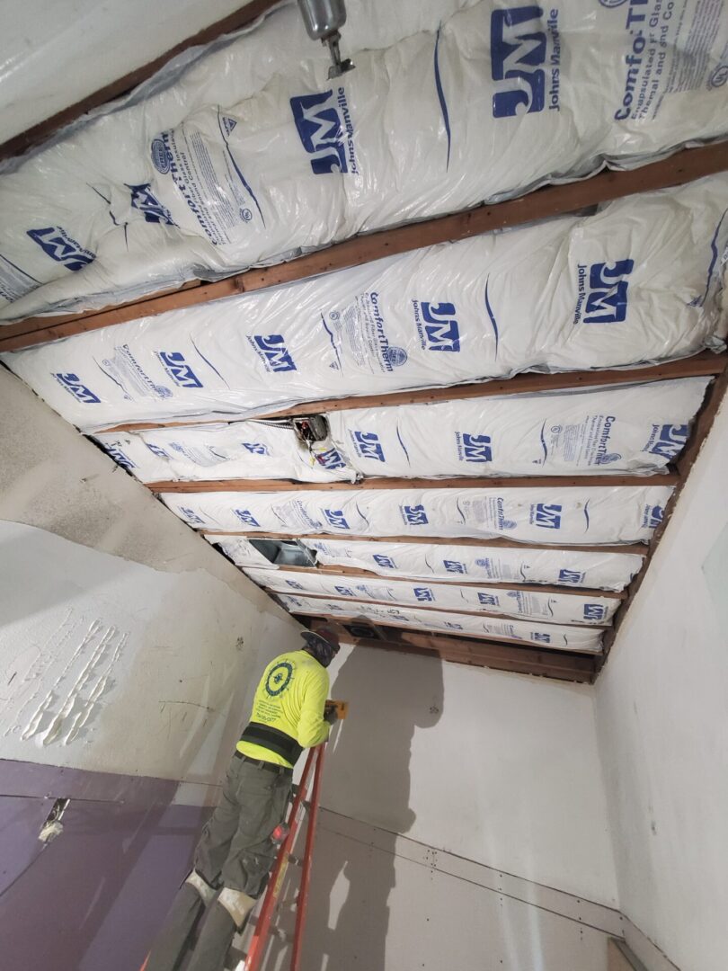 A man standing in front of bags of insulation.