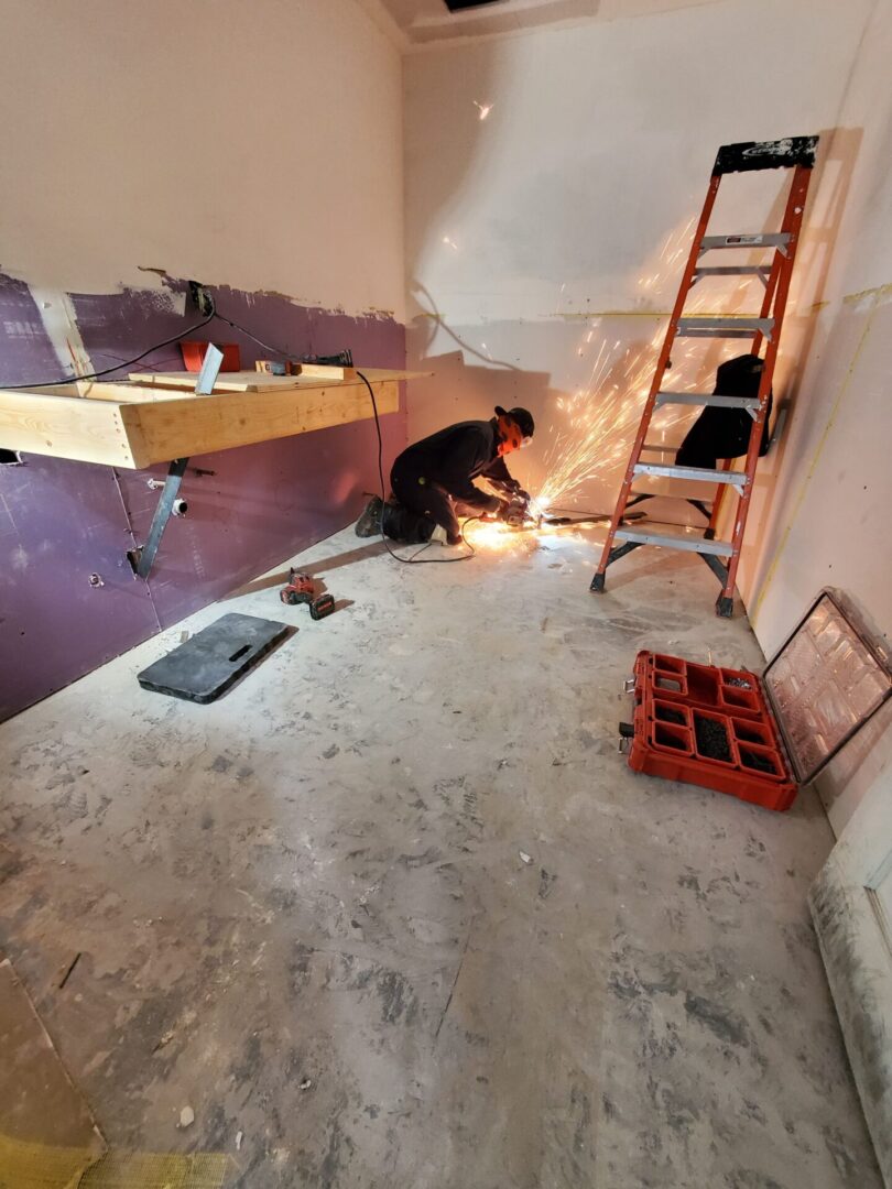 A man working on the floor of a room.