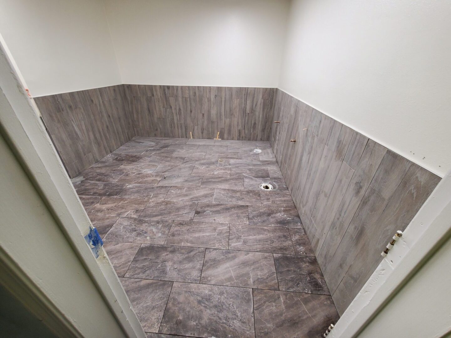 A bathroom with wood tile and white walls.