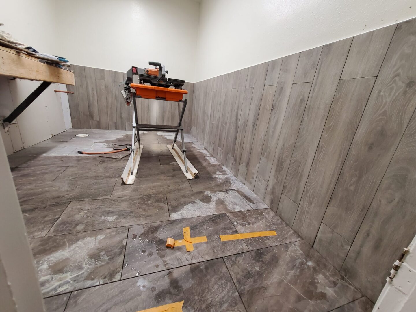 A room with wooden floors and walls being remodeled.