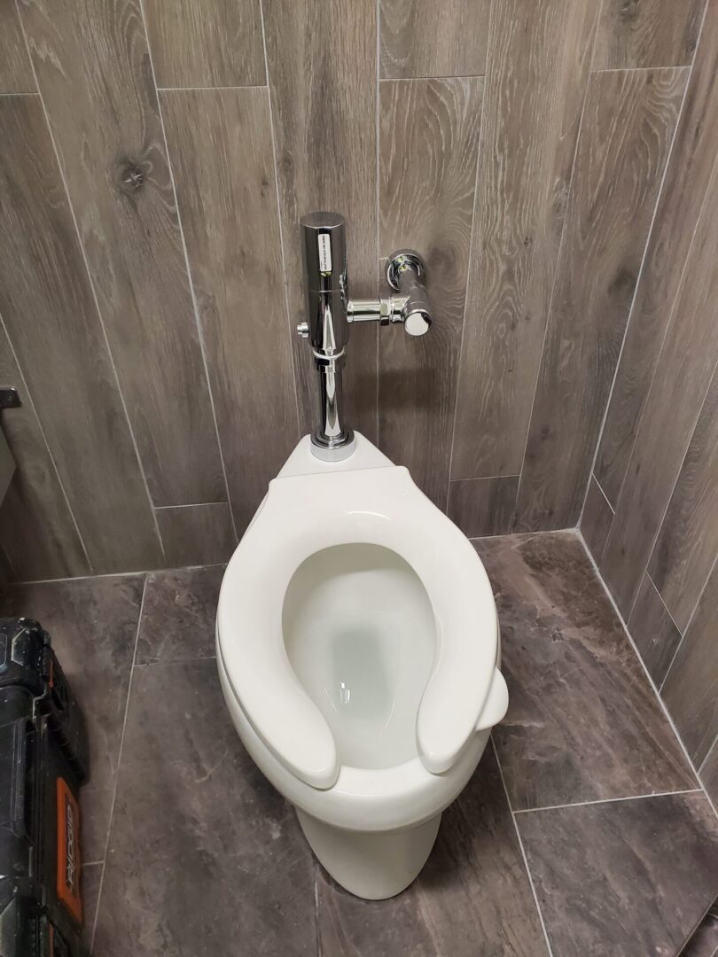 A toilet with the seat up in a bathroom.