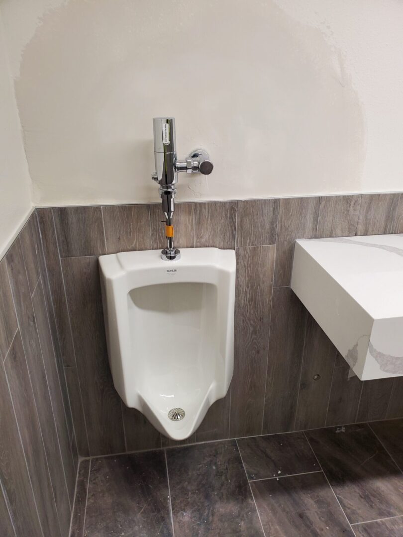 A urinal in the middle of a bathroom stall.