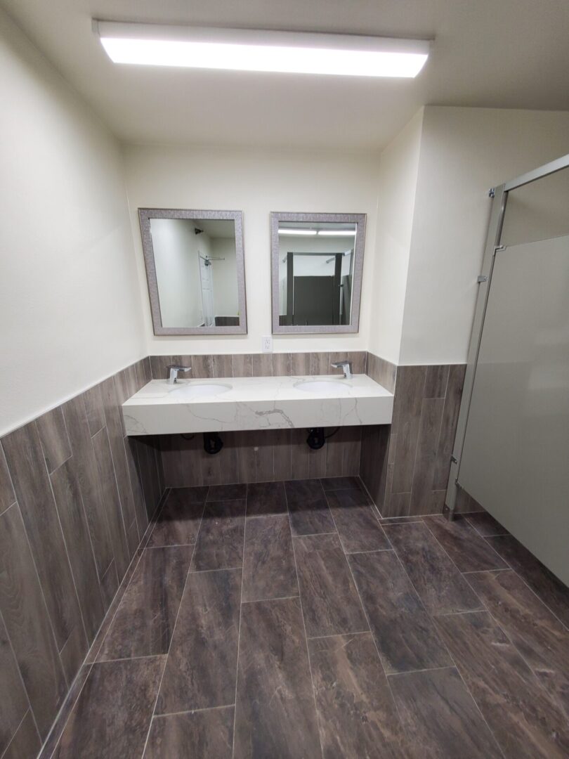 A bathroom with two sinks and a mirror.