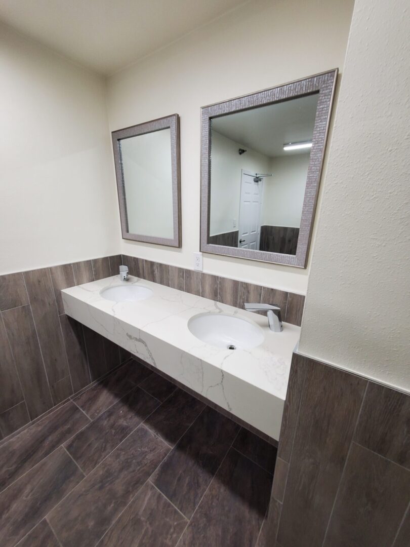 A bathroom with two mirrors and a sink.