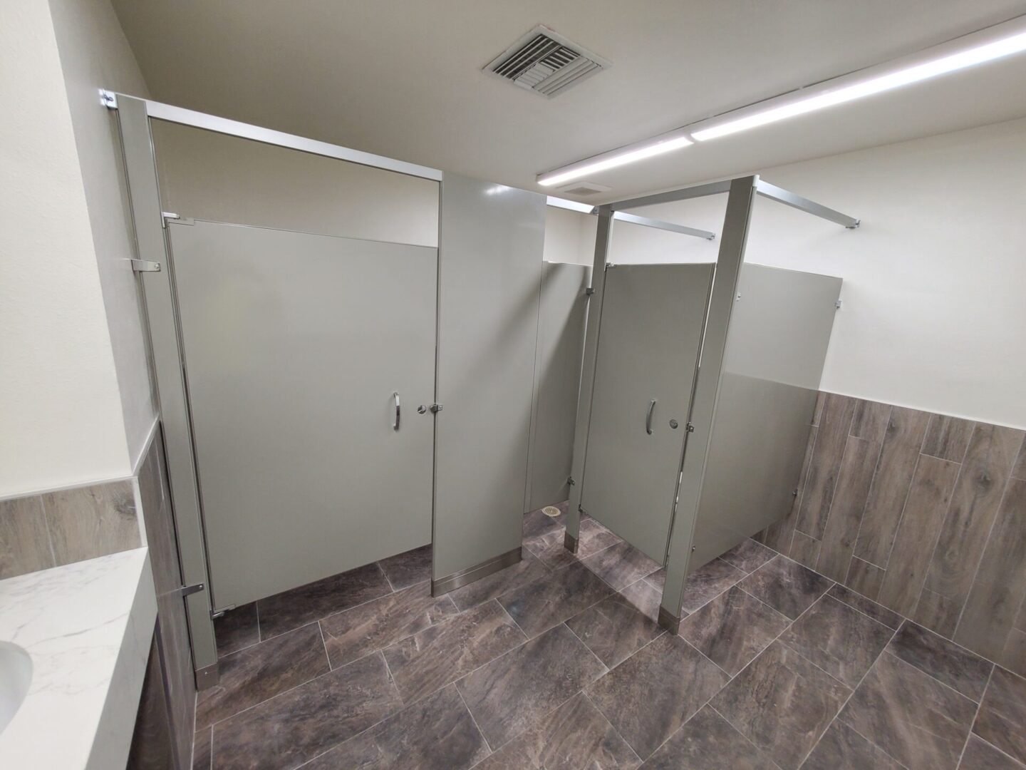 A bathroom with two stalls and three doors.