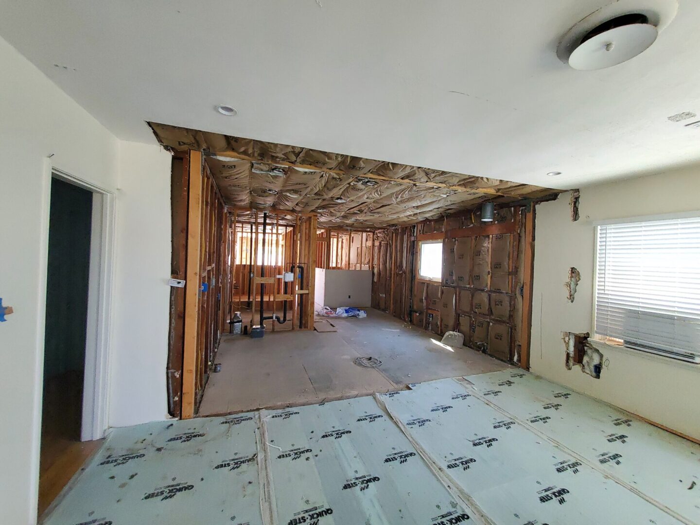 A room with the walls being remodeled and floor in place.