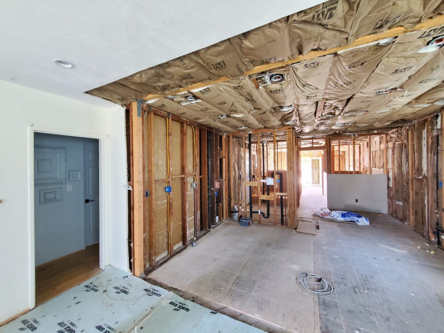 A room being remodeled with the walls and ceiling exposed.