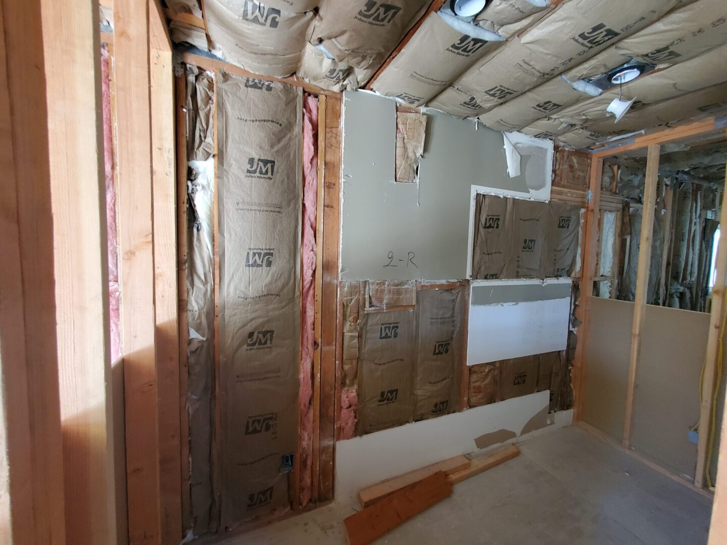 A room with many boxes and insulation on the wall.