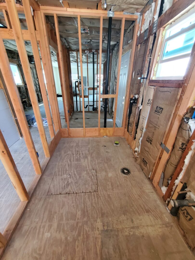 A bathroom being remodeled with wood paneling and wooden floors.