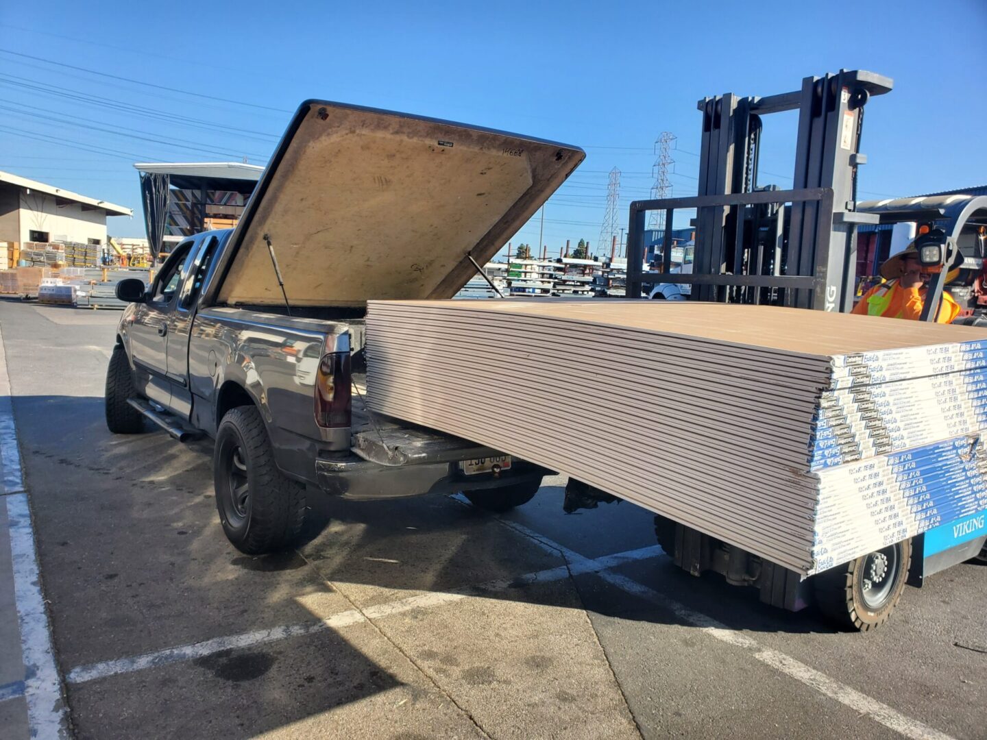 A truck with the back open and its bed lifted.