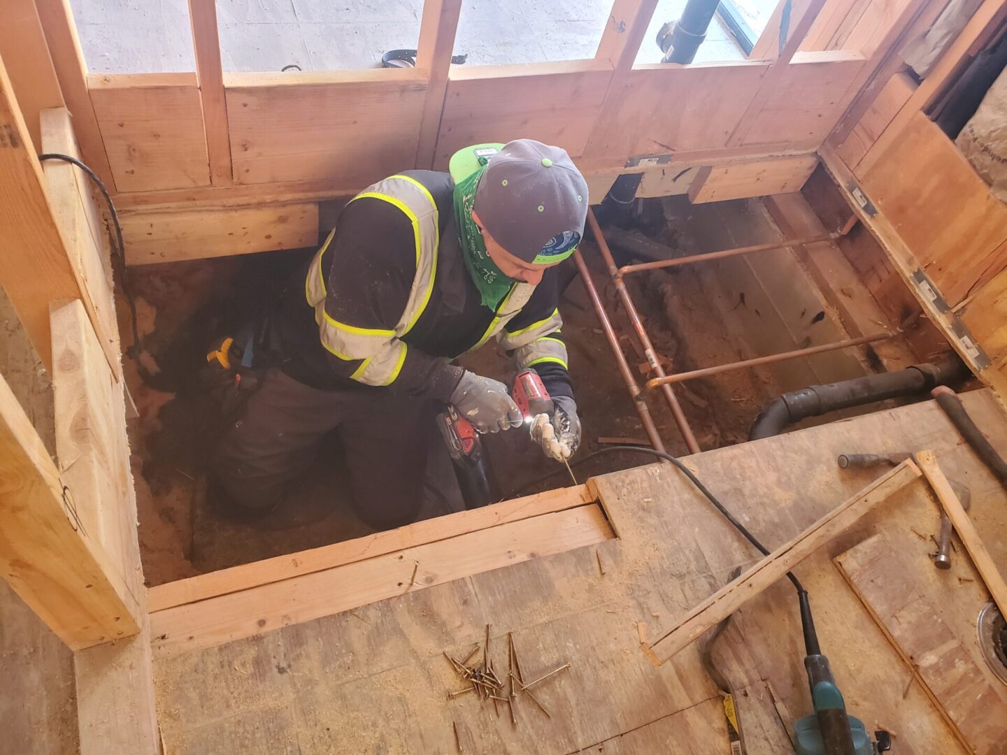 A man in yellow vest standing on top of floor.