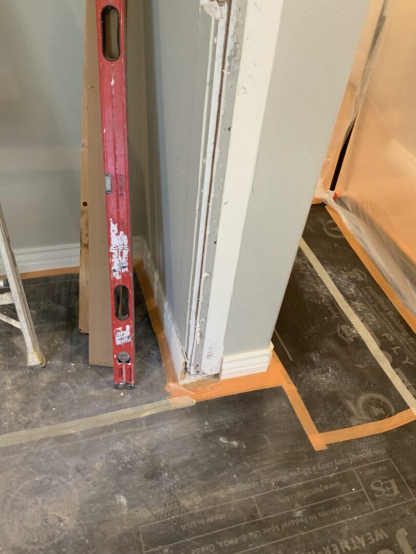 A red ladder leaning against the corner of a room.