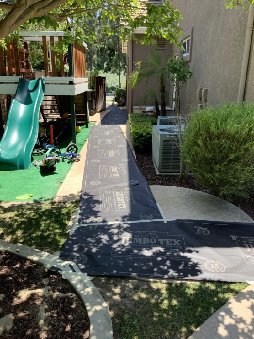 A slide and ramp in the yard of a house.