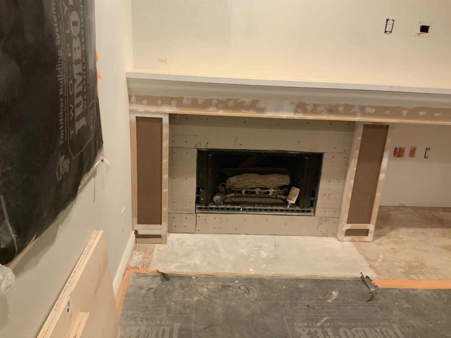 A fireplace in the middle of a room with a painting on the wall.