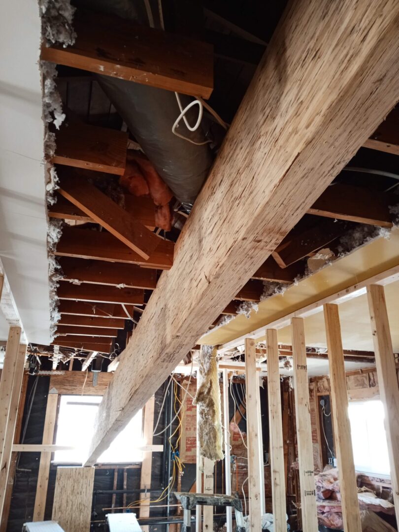 A view of the inside of a house with exposed rafters.