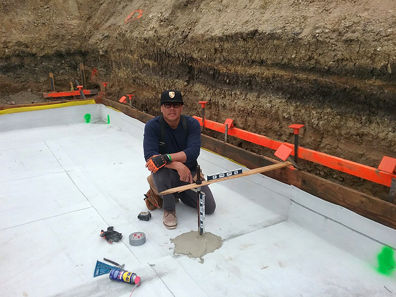 A man sitting on the ground with a baseball bat.