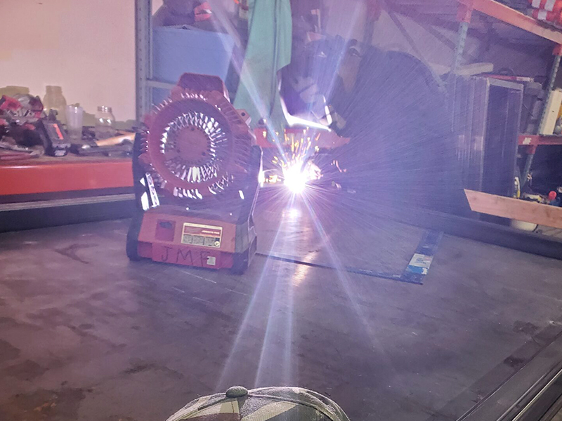 A person welding in the middle of a room.