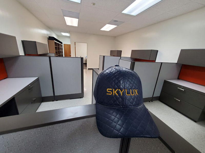 A hat is on top of a desk in an office.